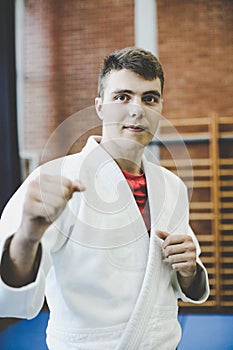 Young male practicing judo in kimono.