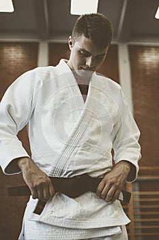Young male practicing judo in kimono.