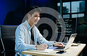 Young male programmer working with tablet and screen displaying code. Modern tech office setup, great for software