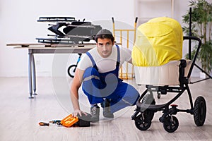 Young male repairer repairing perambulator indoors