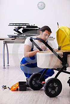 Young male repairer repairing perambulator indoors