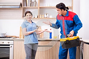 Young male repairman repairing washing machine