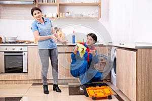 Young male repairman repairing washing machine