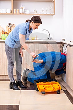 Young male repairman repairing washing machine