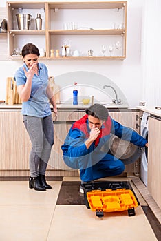 Young male repairman repairing washing machine