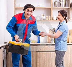 Young male repairman repairing washing machine