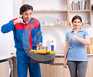 Young male repairman repairing washing machine