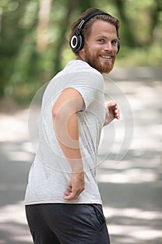 young male runner jogs in park