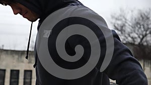 Young male runner warming up before training at sports ground. Strong sportsman preparing to workout outdoor. Sporty man