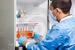 Young male scientist and laboratory freezer