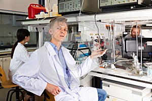 Young male scientist sitting at biochemical lab