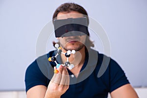 Young male scientist sitting in the classroom