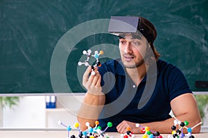 Young male scientist sitting in the classroom