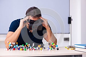 Young male scientist sitting in the classroom