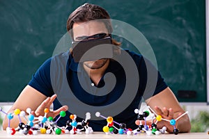 Young male scientist sitting in the classroom