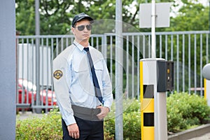 Security Guard Standing Beside Car Parking Machine