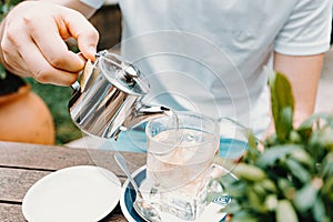 Young male serving an ice tea in a modern bar