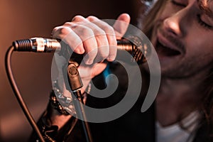 Young male singer with microphone on stage