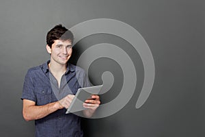Young male smiling using digital tablet