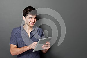 Young male smiling using digital tablet