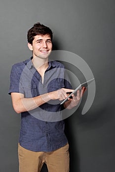 Young male smiling using digital tablet