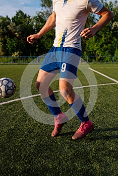 Young male soccer player juggles a ball on a soccer field