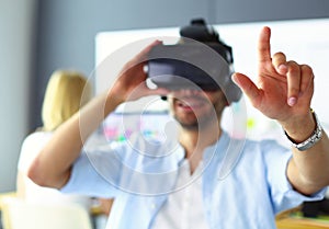 Young male software programmer testing a new app with 3d virtual reality glasses in office.