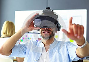 Young male software programmer testing a new app with 3d virtual reality glasses in office.