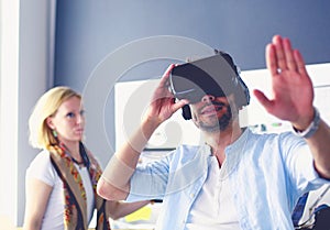 Young male software programmer testing a new app with 3d virtual reality glasses in office.