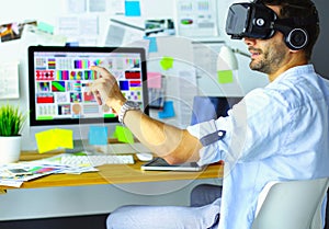 Young male software programmer testing a new app with 3d virtual reality glasses in office.