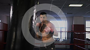 Young male sportsman athlete training in boxing gym