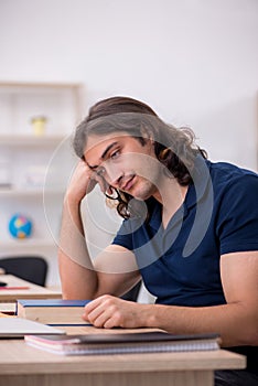 Young male student being tired during exam preparation