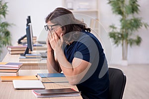 Young male student being tired during exam preparation