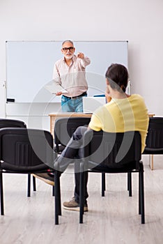 Young male student and experienced teacher in pandemic concept