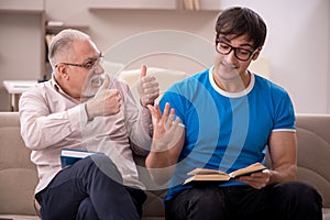 Young male student and his grandfather at home