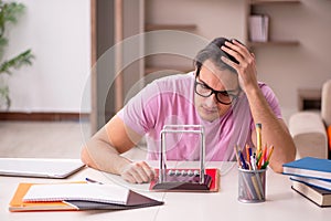 Young male student physicist preparing for exam at home