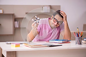 Young male student physicist preparing for exam at home
