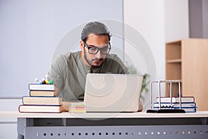 Young male student physicist in tele-education concept