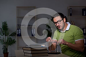 Young male student physicist working hard at night time