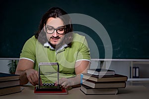 Young male student physicist working hard at night time