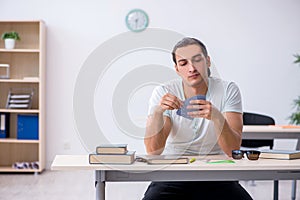 Young male student playing cards during exam preparation in the