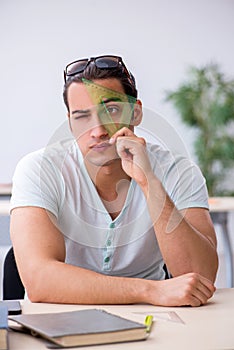 Young male student preparing for exam in the classroom