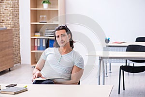 Young male student preparing for exam in the classroom