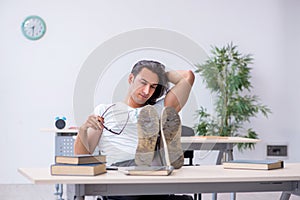 Young male student preparing for exam in the classroom