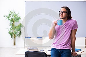 Young male student preparing for exams at classroom