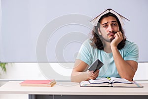 Young male student preparing for exams in the classroom