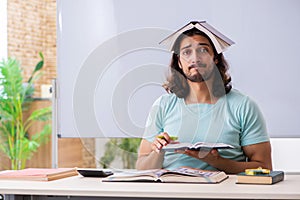 Young male student preparing for exams in the classroom