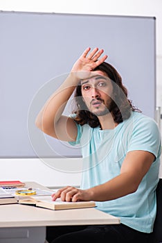 Young male student preparing for exams in the classroom