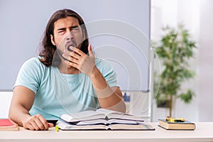 Young male student preparing for exams in the classroom