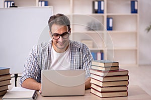 Young male student preparing for exams in the classroom